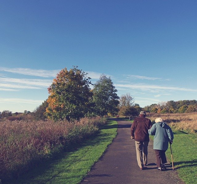 二人三脚で長い道を歩く老夫婦